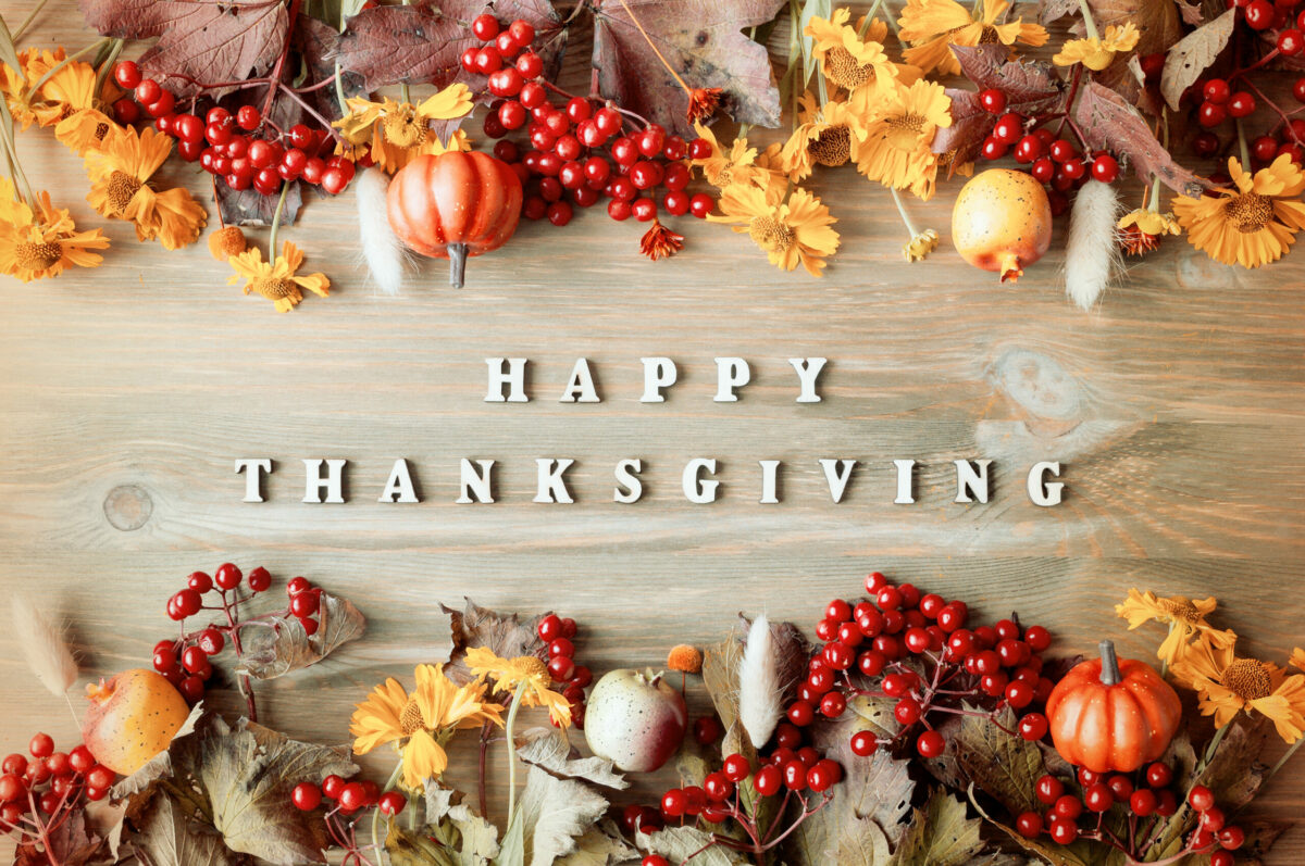 Thanksgiving day autumn background with with Happy Thanksgiving letters, seasonal autumn berries, pumpkins, apples
